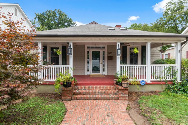 Beautiful home with professional landscaping featuring brick walkway and manicured gardens